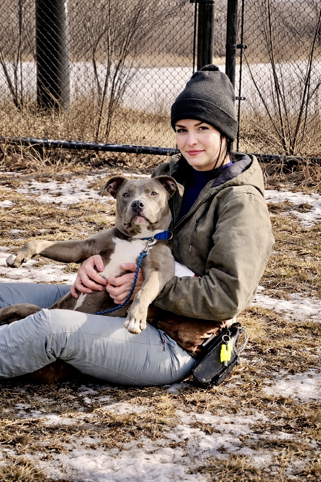 Lauren seated outdoors with a dog